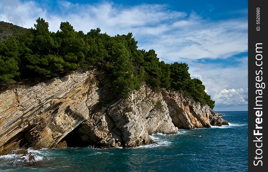 Mediterranean coastline with rock and cloudy sky