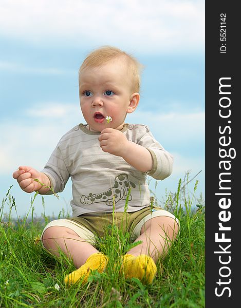 Little baby  on green grass with flower