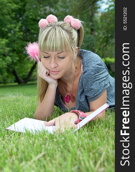 Beauty girl with book on green grass