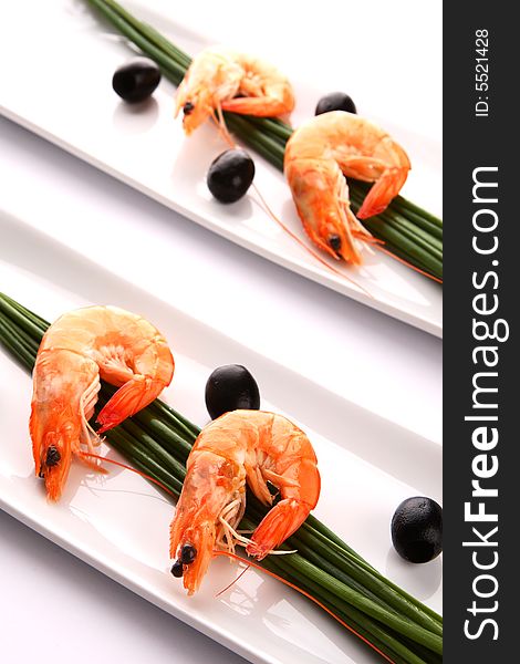 Fresh shrimps with chive and oil on white plate