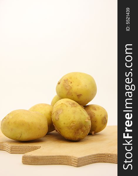 Potatoes on isolated white background over wooden kitchen board