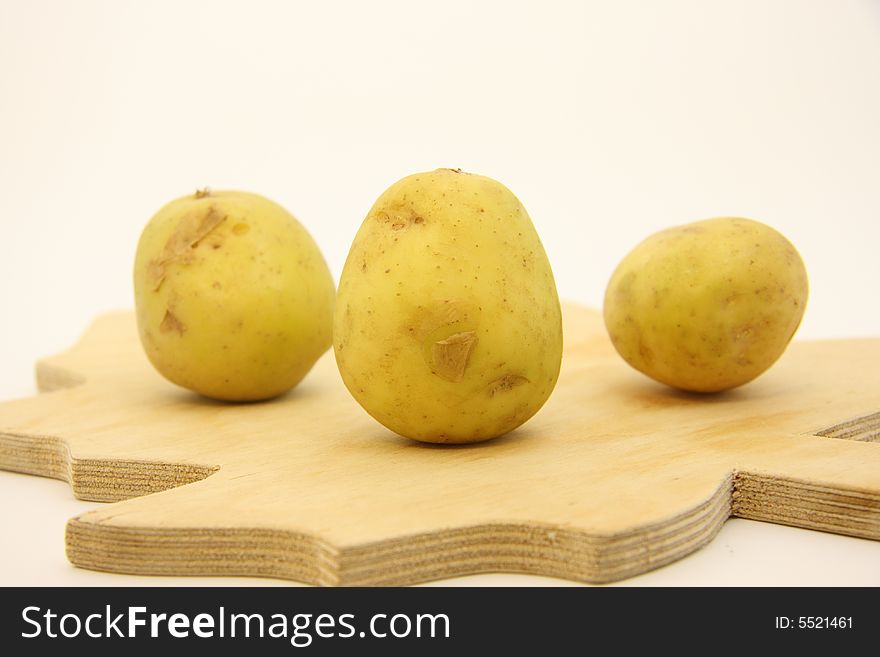 Potatoes on isolated white background over wooden kitchen board