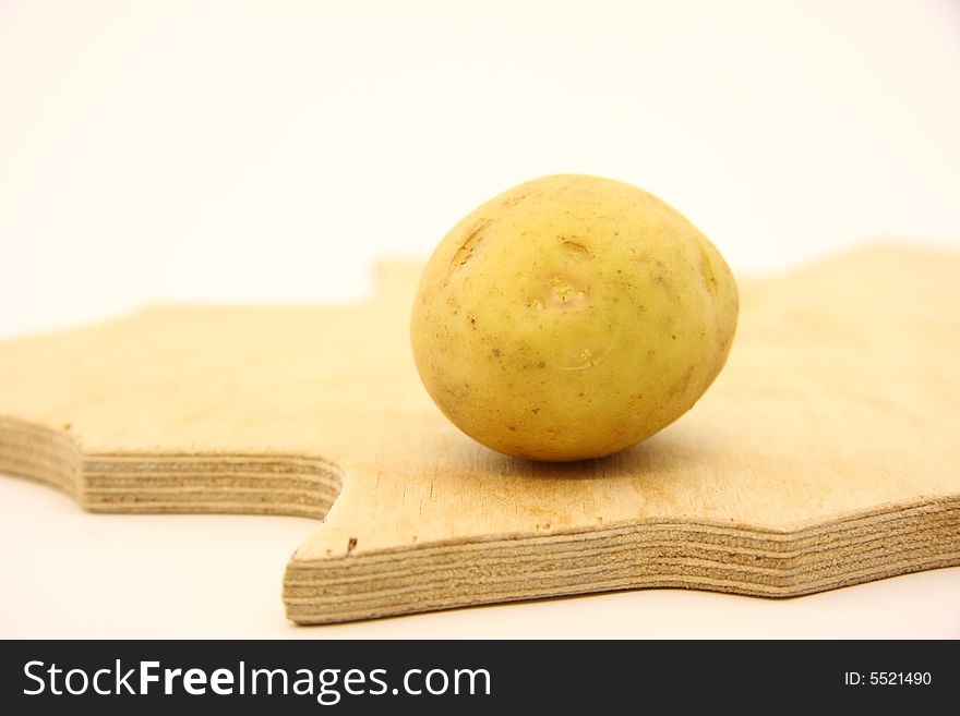 Potato on wooden kitchen board on isolated white background