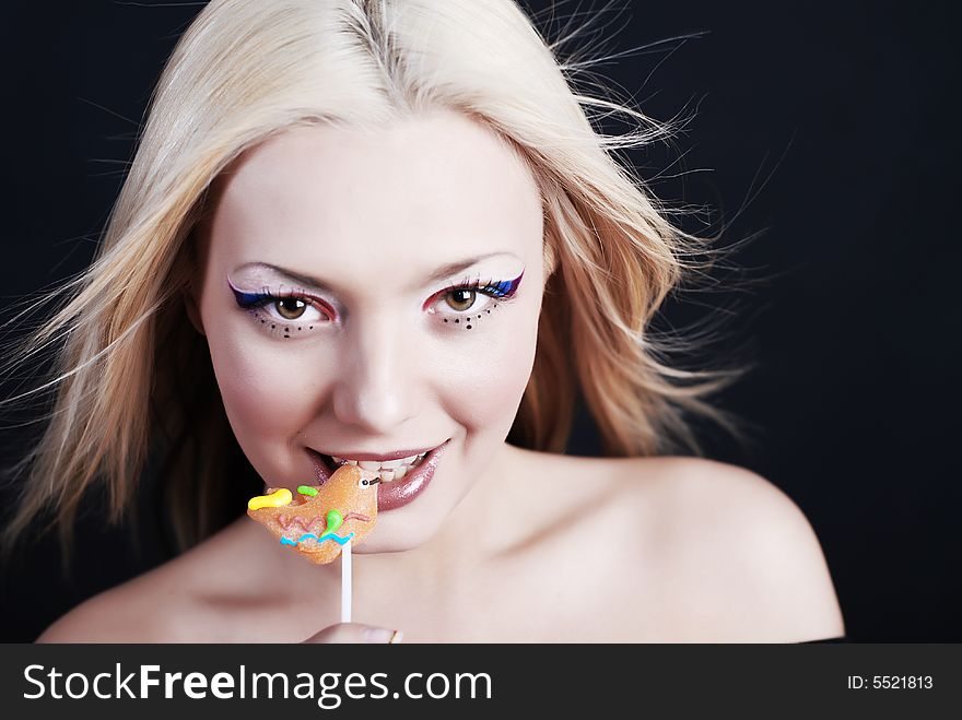 Beautiful young girl with bright make-up and lollipop in her mouth. Beautiful young girl with bright make-up and lollipop in her mouth