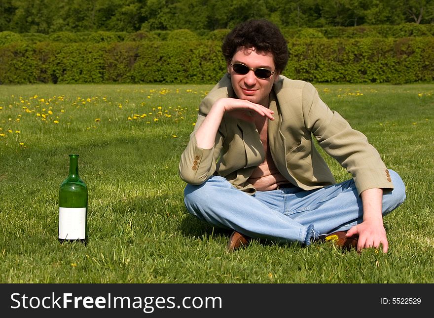 Cheerful drunk man on a meadow