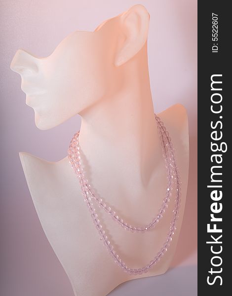 Pink crystal necklace shown on a frosted glass display stand with soft pink background. Pink crystal necklace shown on a frosted glass display stand with soft pink background