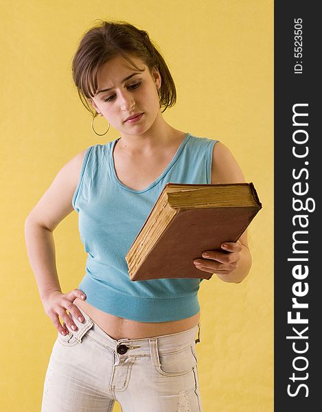 Young student girl holding her books on yelow backgrounds