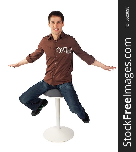 Young man sits on stool.