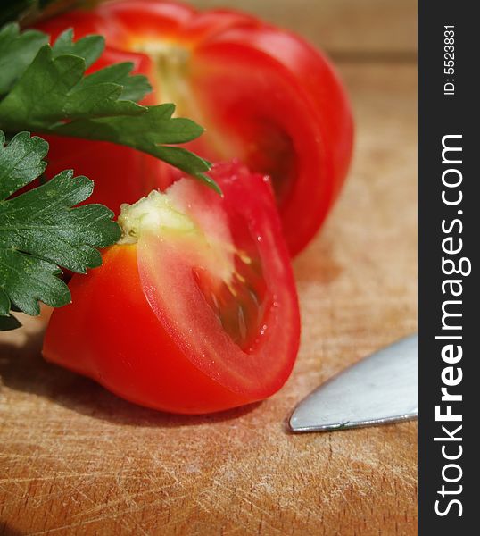 A sliced tomato on a wooden cutting board. A sliced tomato on a wooden cutting board.