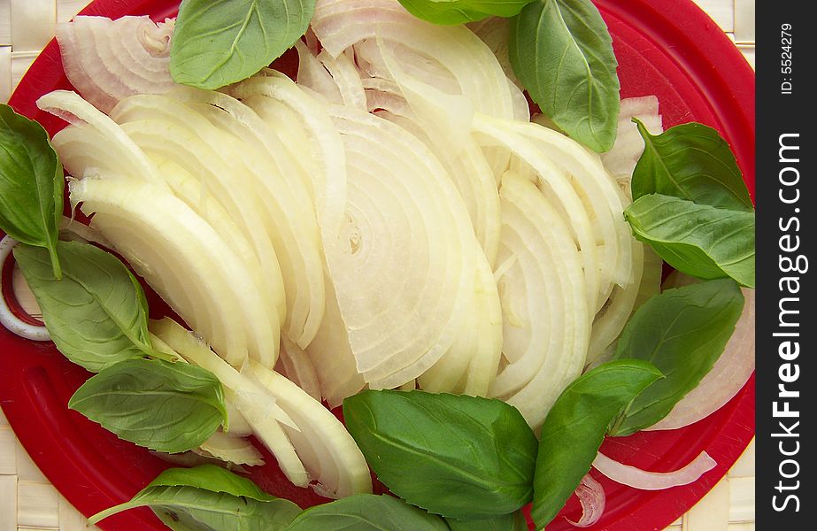 Red plank with sliced onion and basil