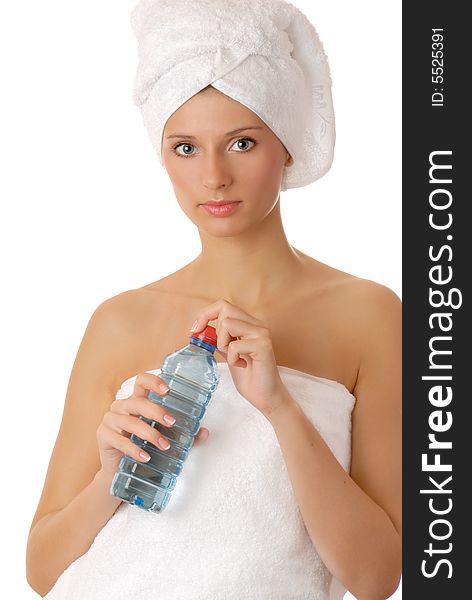 Relaxed girl in white towel with bottle of water after spa treatment isolated on white. Relaxed girl in white towel with bottle of water after spa treatment isolated on white