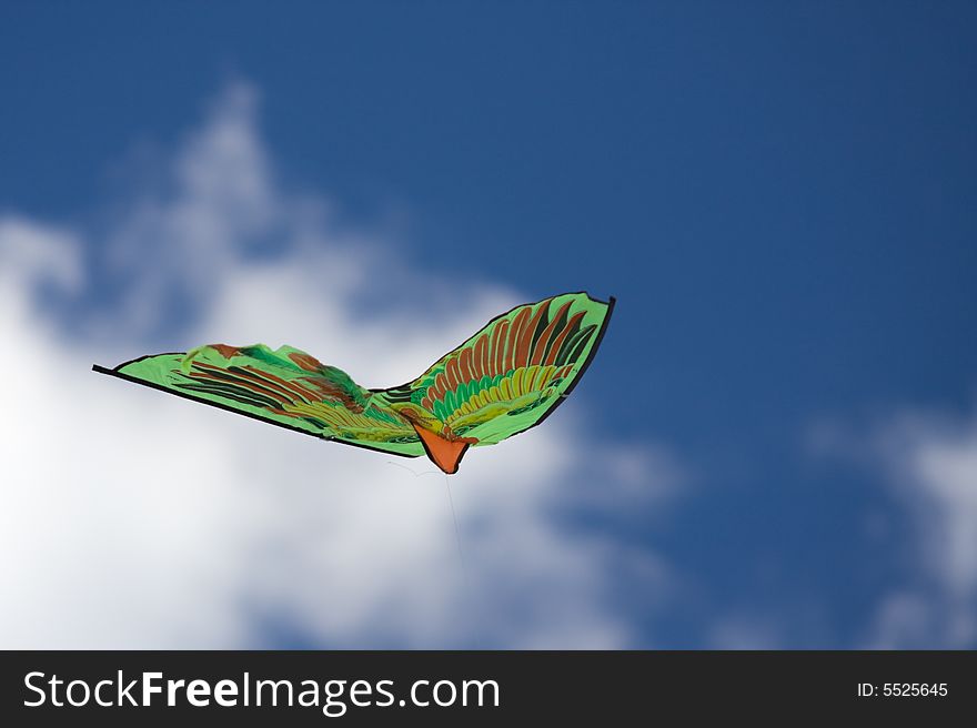 Green kite flying in the blue sky. Green kite flying in the blue sky