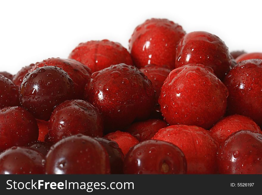 A lot of fresh red cherry with drops on background