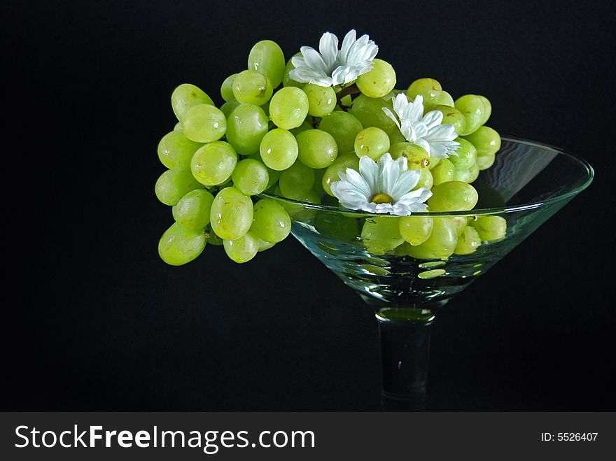 Green grapes and summer daisies in a large glass. Green grapes and summer daisies in a large glass.