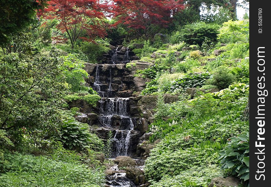 Water drops down a lush green waterfall.