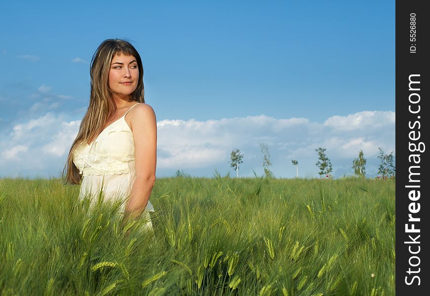 Beautiful young woman in grean field looking right. Beautiful young woman in grean field looking right