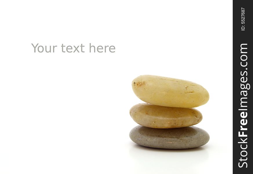 Pile of three pebbles on a white surface