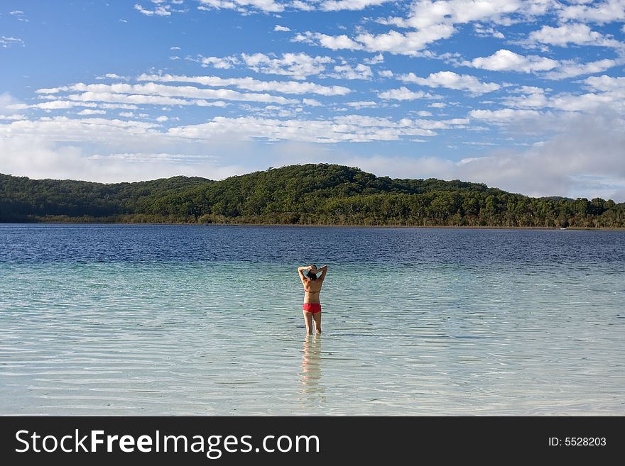 Young girl standing in the tranquil lake