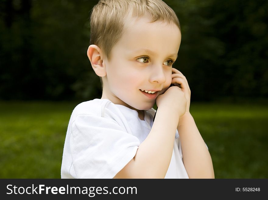 Child Talking By Phone Outdoors
