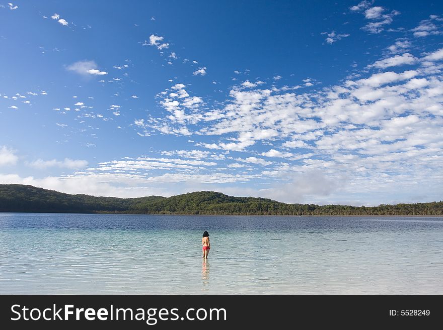 Young girl standing in the tranquil lake