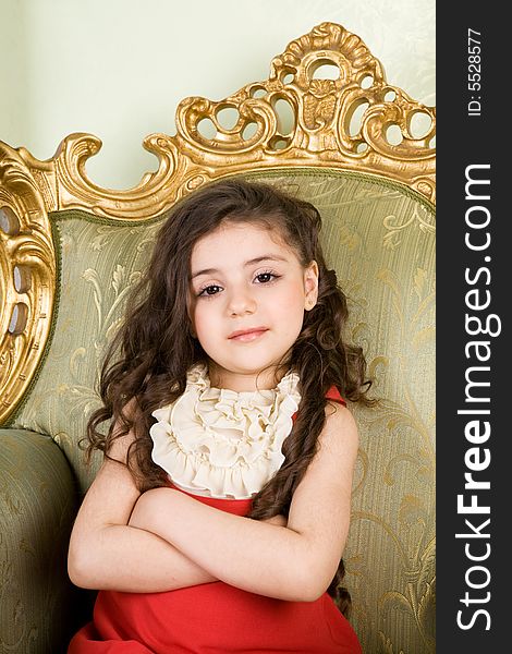 Small girl with long hair in the armchair. Small girl with long hair in the armchair