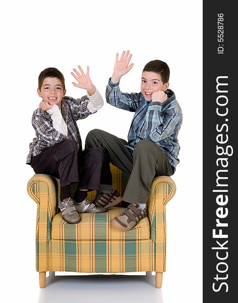 Two young happy smiling boys sitting on the back of the chair. Two young happy smiling boys sitting on the back of the chair