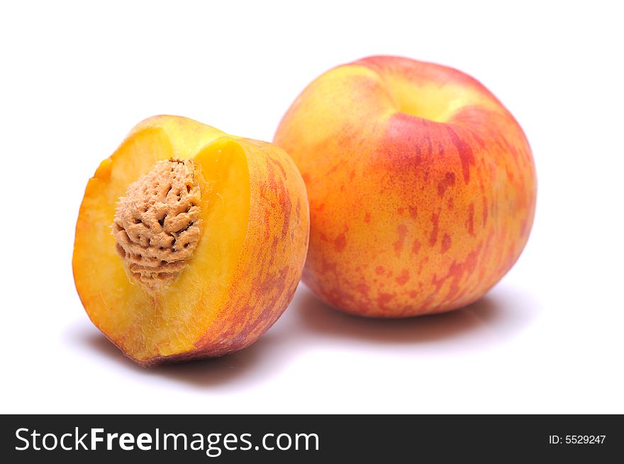 Whole and half peach on white background. Whole and half peach on white background