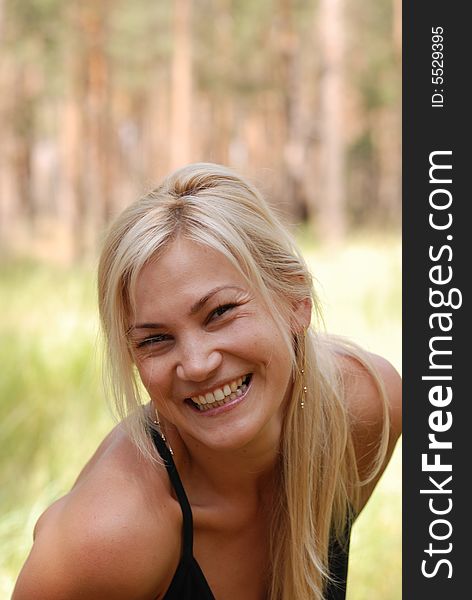 The girl  blonde. In a black blouse and a happy smile on the person. The girl  blonde. In a black blouse and a happy smile on the person