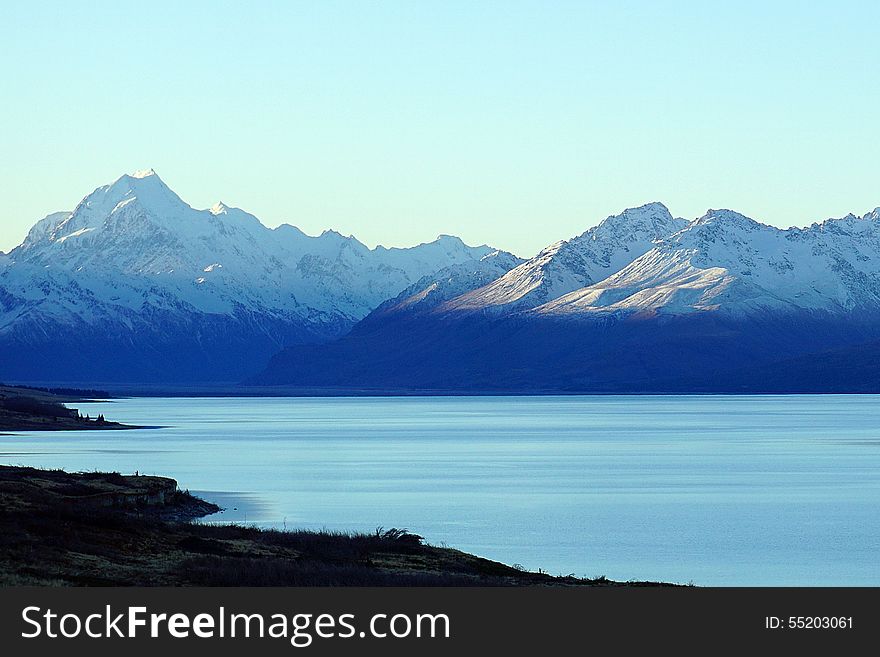 Snow covered peaks of Mount Cook across Lake Pukaki in New Zealand. Snow covered peaks of Mount Cook across Lake Pukaki in New Zealand.