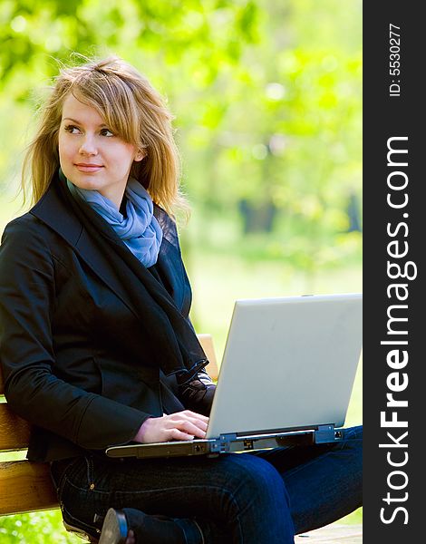 Pretty young model with laptop at park. Pretty young model with laptop at park
