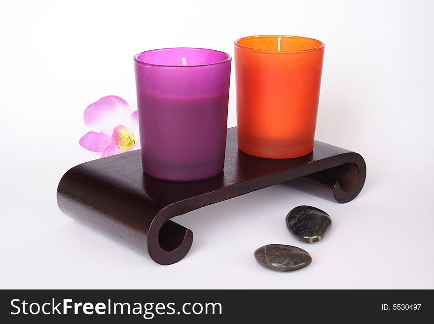 Color candles and pebbles in white background