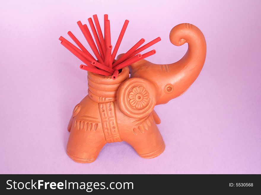 Incense sticks on  elephant holder in color background