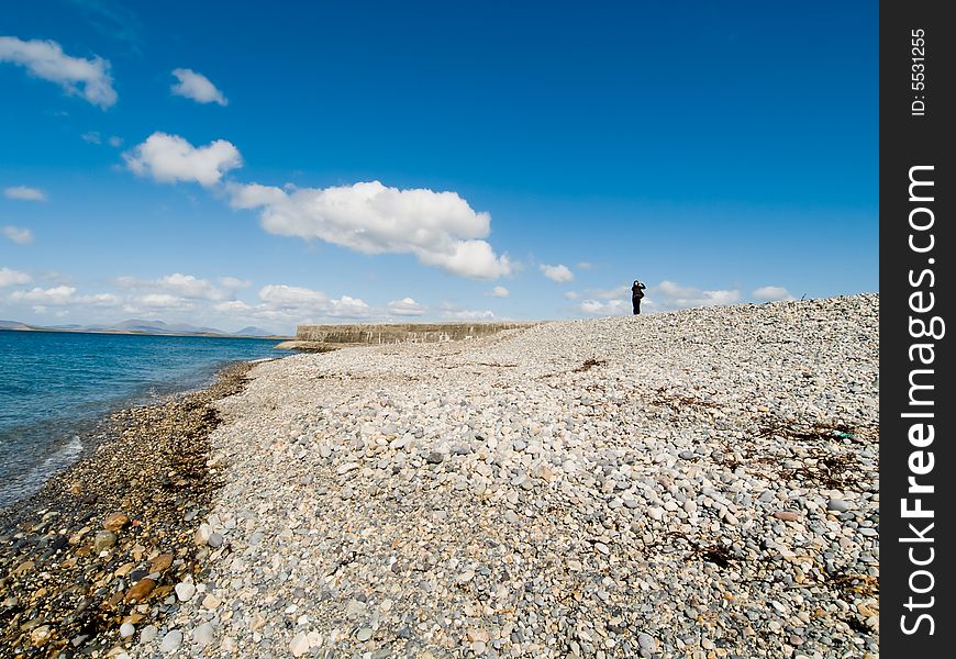 Lonely person on the stone beachy. Lonely person on the stone beachy