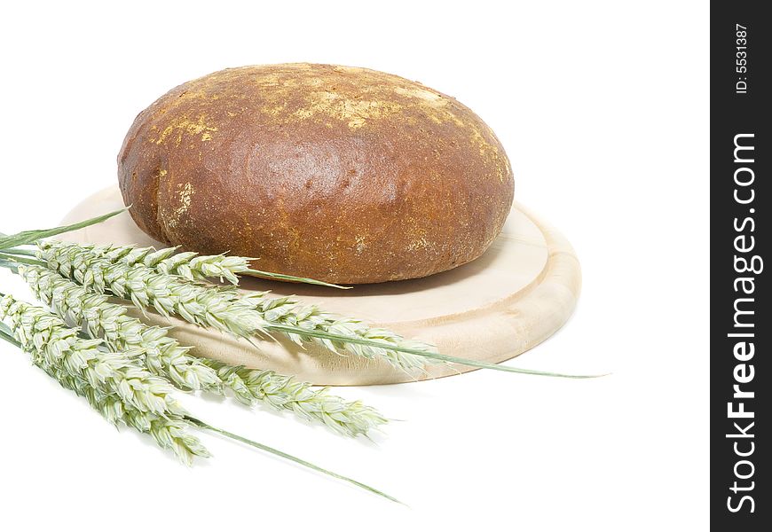 Fresh round bread with wheat on white background