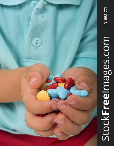 Closeup of young boy hands holding heart shaped candies. Closeup of young boy hands holding heart shaped candies