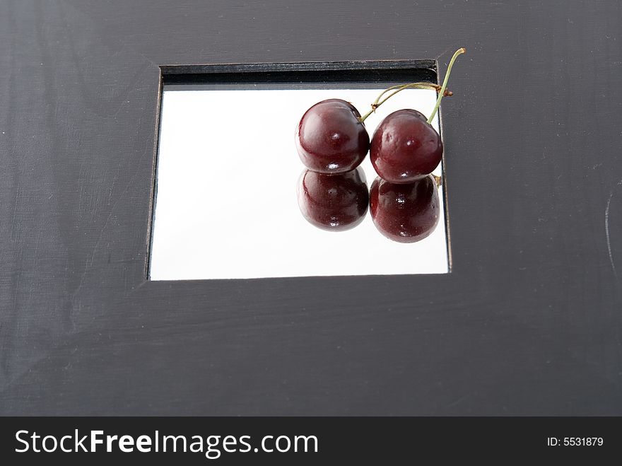 Two cherry on a mirror with black border. Two cherry on a mirror with black border