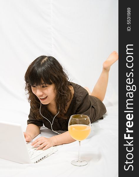 A asian female adolescent in brown skirt with light brown curved hair is enjoying the chatting with her online friends. White she is also enjoying the orange juice. A asian female adolescent in brown skirt with light brown curved hair is enjoying the chatting with her online friends. White she is also enjoying the orange juice.