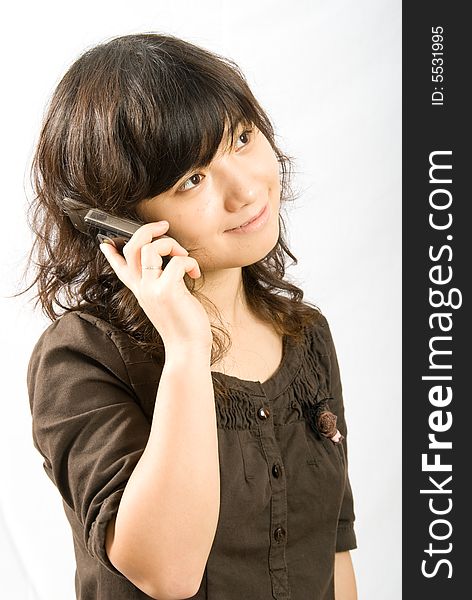 A asian female adolescent in brown skirt with light brown curved hair is calling her boyfriend with a slide hand phone. A asian female adolescent in brown skirt with light brown curved hair is calling her boyfriend with a slide hand phone.