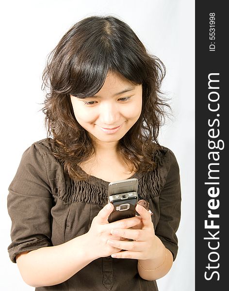 A girl is sending a short message through her slide type hand phone. A girl is sending a short message through her slide type hand phone.