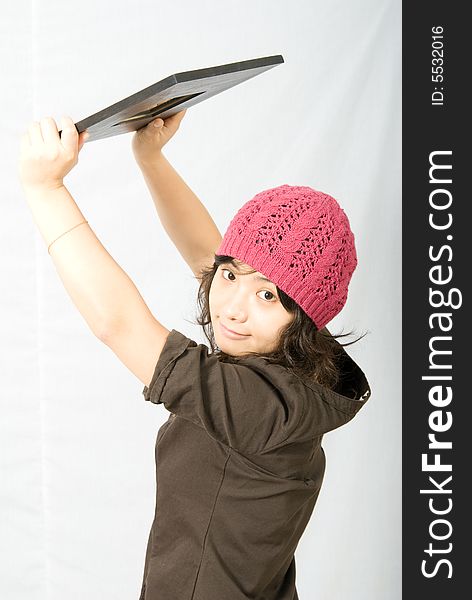 Cute asian girl with pink and red hat holds up a mirror.