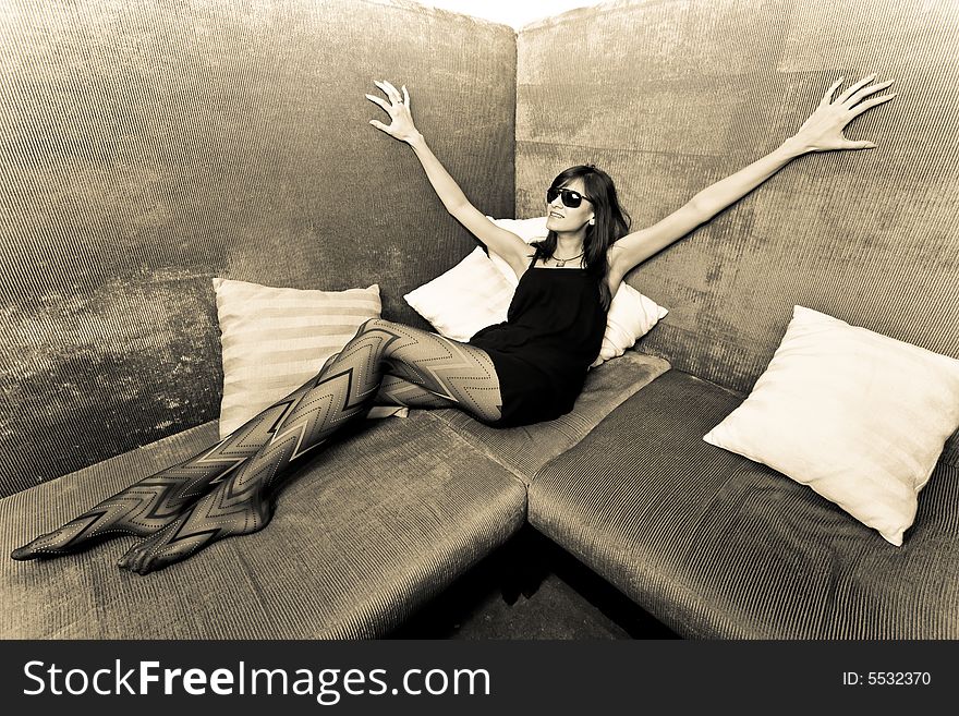 Young attractive female adult sitting on sofa. Young attractive female adult sitting on sofa