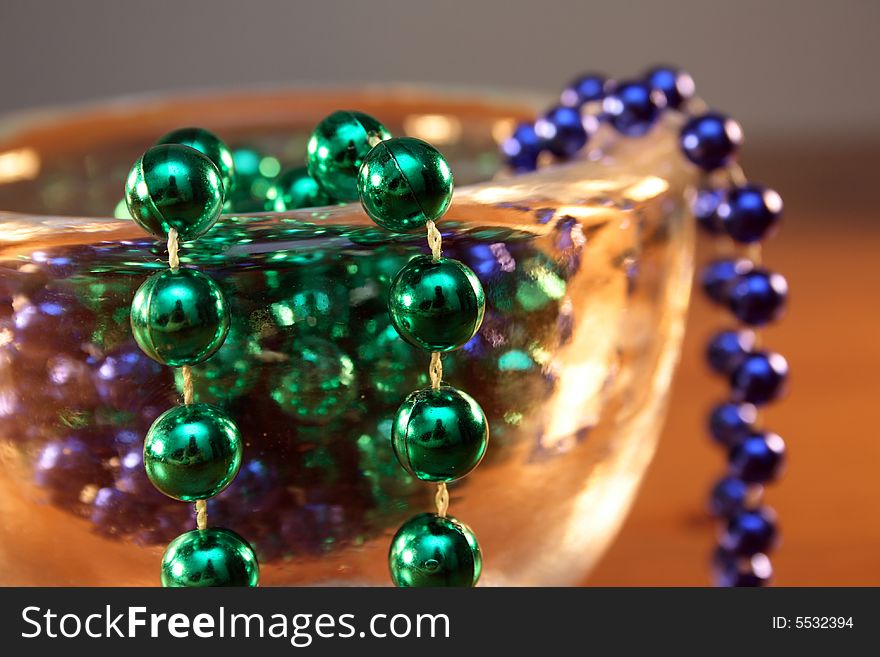 Necklace with green and blue pearls in a bowl