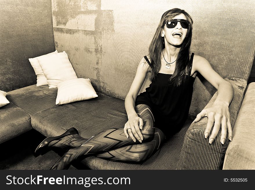 Young attractive female adult sitting on sofa and screaming