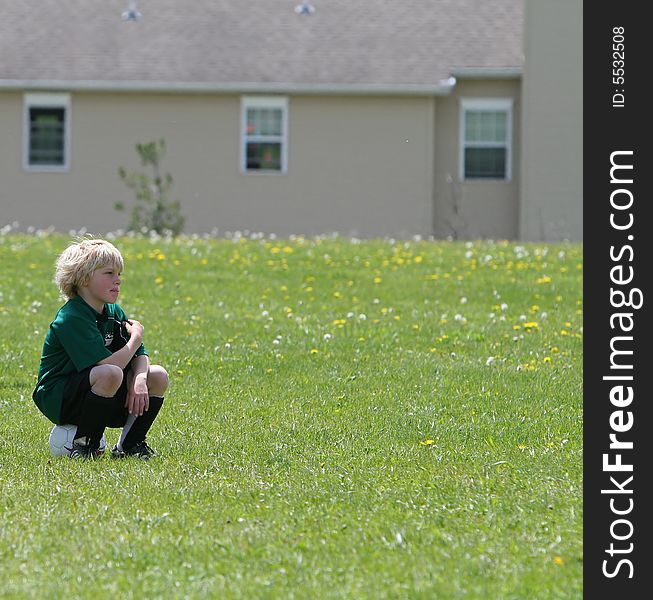 Young boy waiting for the sign to go in and play soccer. Young boy waiting for the sign to go in and play soccer