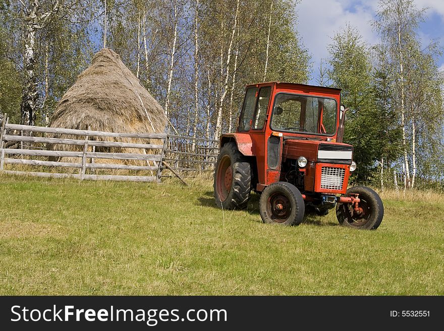 Image of a tractor in a mountain rural area.