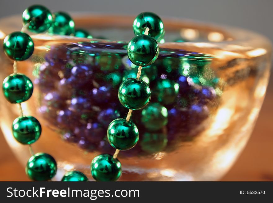 Necklace with green and blue pearls in a bowl