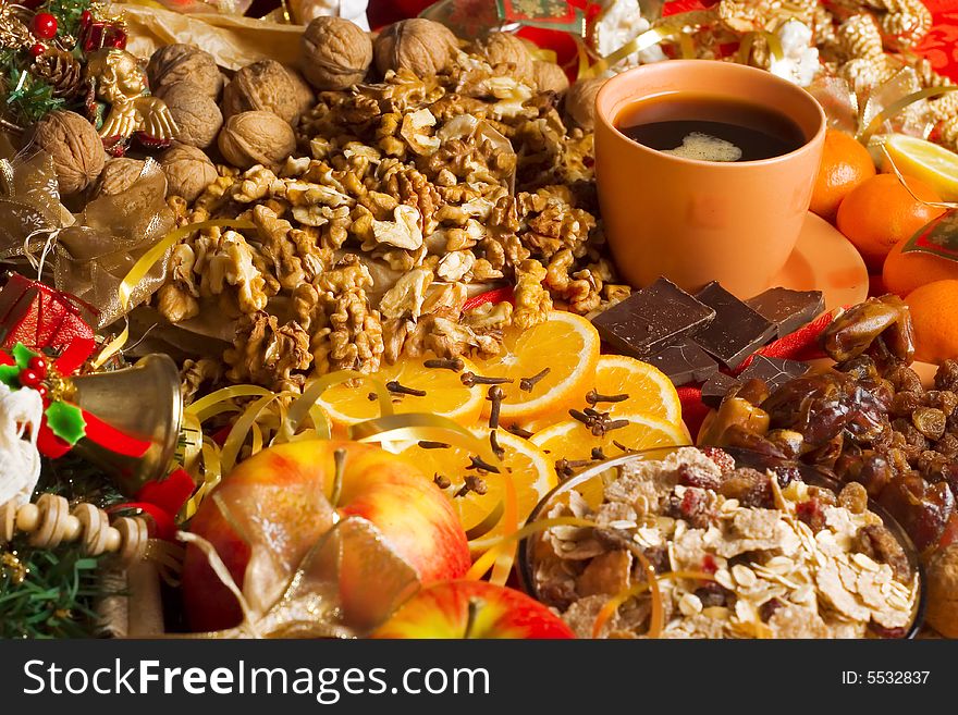 Christmas background - walnuts, oranges, apples, cup of coffee