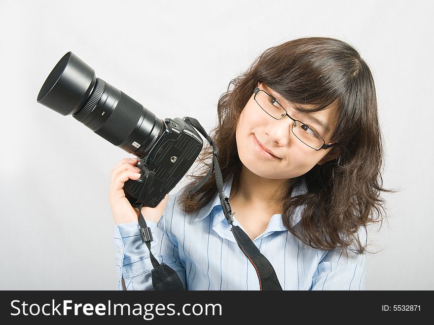 A young female photographer is holding a profession black digital camera. A young female photographer is holding a profession black digital camera