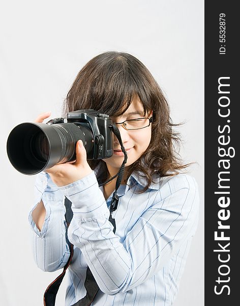 A young female photographer is shooting through a profession black digital camera. A young female photographer is shooting through a profession black digital camera