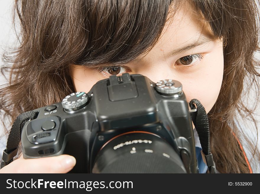 A close up photo of a young female photographer when she is looking through the viewfinder. A close up photo of a young female photographer when she is looking through the viewfinder.